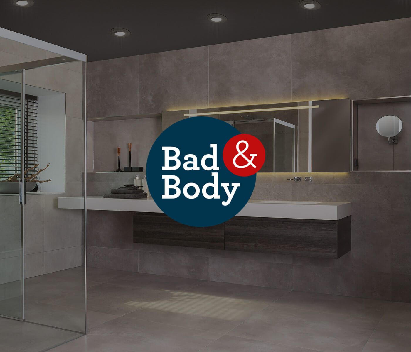 Moderne badkamer met grijze tegels en Bad & Body-logo.
