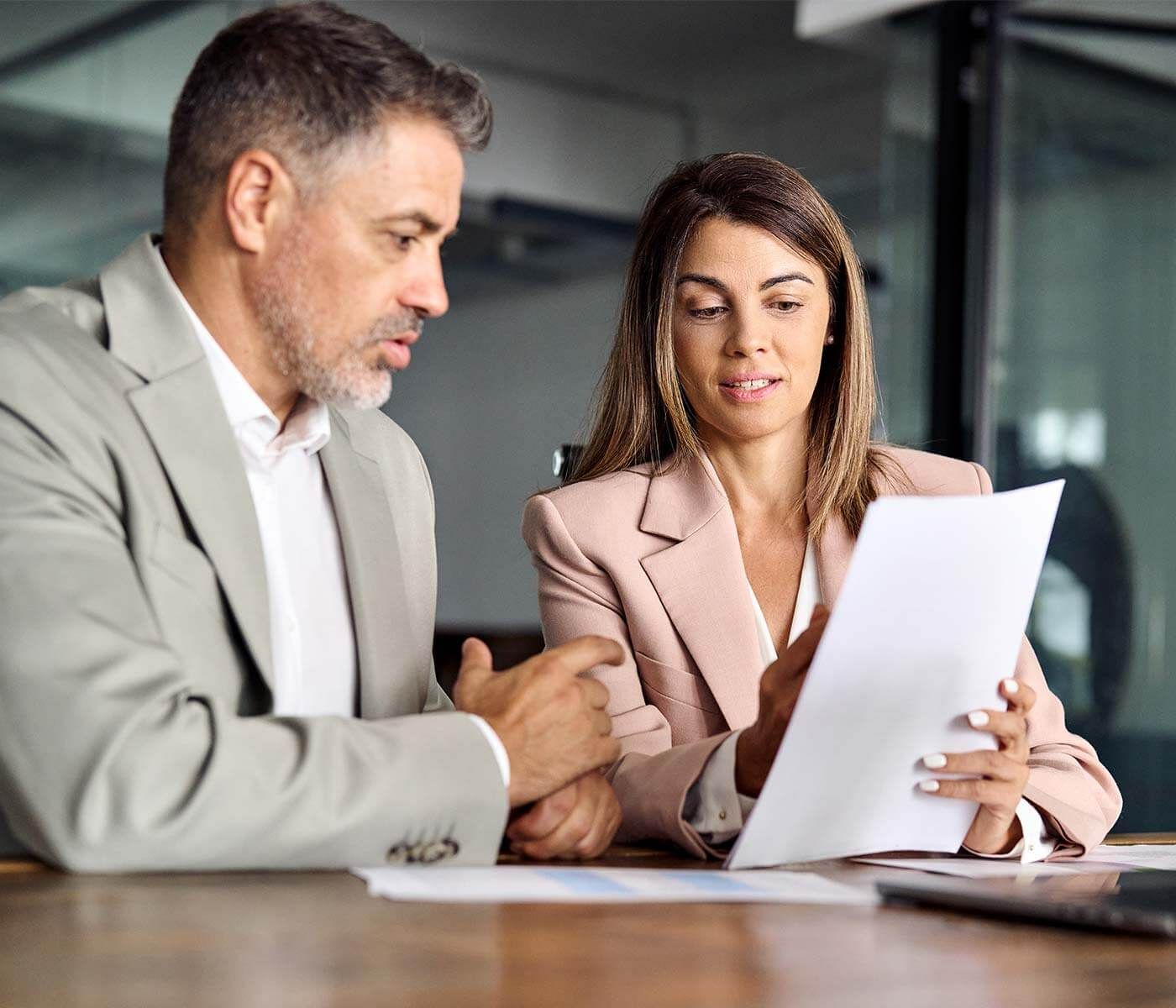 Twee zakenpartners bespreken documenten tijdens een vergadering.